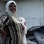 A woman, Ahlam, outside her destroyed house.